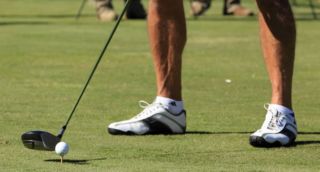 Golfer taking a shot highlighting physical demands of the sport