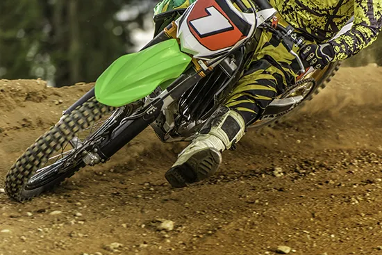 Group of motocross riders navigating a dirt track corner during a high-speed race
