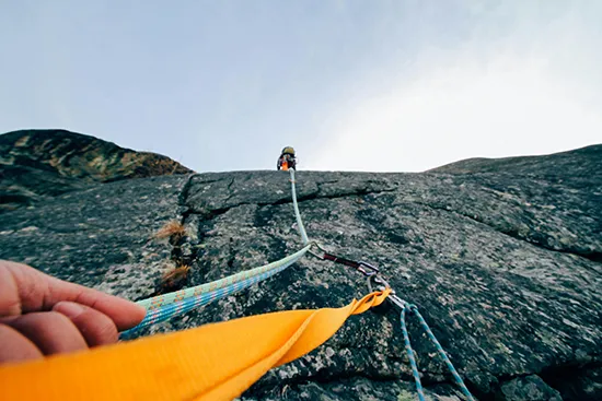 Point of view of a climber pulling up a rope during a rock climbing ascent