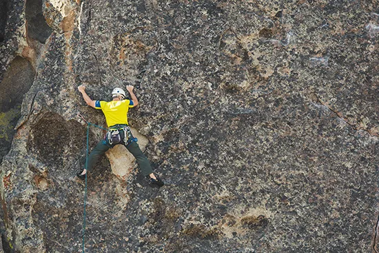Experienced rock climber tackling a steep and technical outdoor climbing route