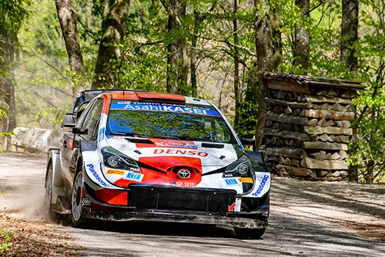 Rally car racing on off-road terrain highlighting control and high-speed driving conditions