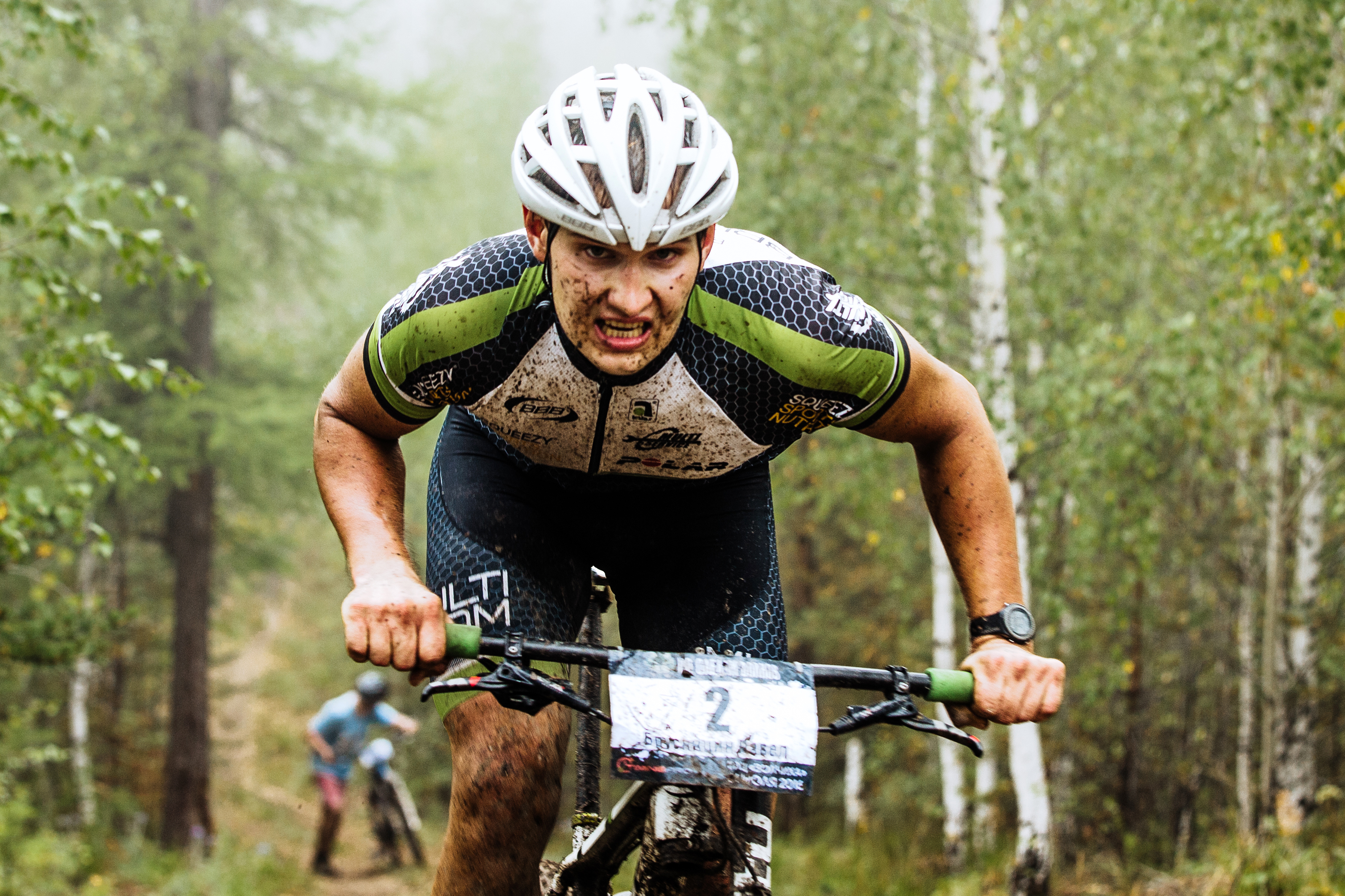 Mountain bike rider racing through muddy terrain demonstrating physical demands and risk in mountain biking